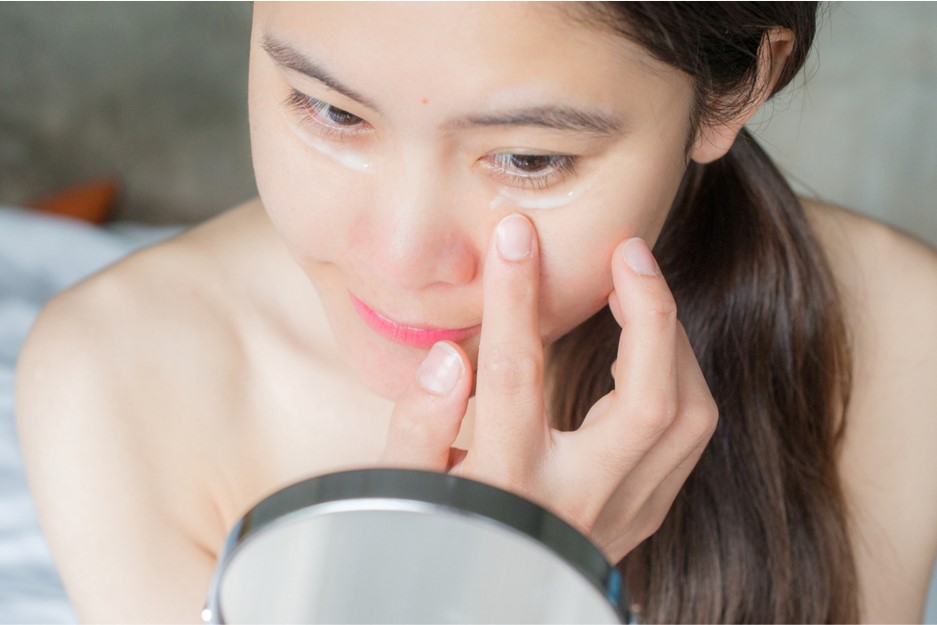 Woman put a cream under their eye bags